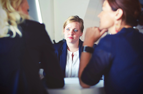Image of a woman actively listening to others during a meeting